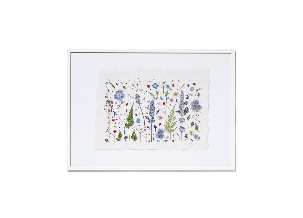 A framed botanical art featuring delicate flowers in blue, purple, green, and red on a white background, enclosed in a white frame.