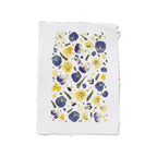 A square white textured paper with yellow and purple pansies with green leaves on a white background.