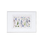 A framed botanical art featuring delicate flowers and leaves in soft blue, purple, green, and red tones on a white background, presented in a white frame against a clean white backdrop.