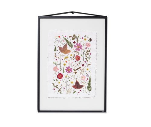 A framed botanical art featuring colourful flowers, leaves, and birds on a white textured background, enclosed in a black frame with a hanging loop at the top.